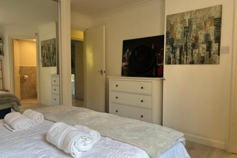 Spacious and tidy master bedroom featuring a co...