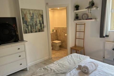 A bright and inviting master bedroom featuring ...