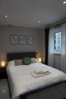 A stylish and cozy master bedroom featuring a n...