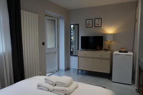A neat and modern double bedroom featuring a co...