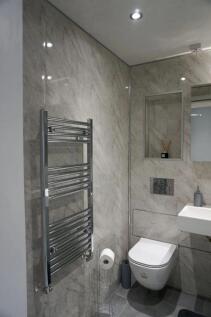 A modern and sleek single toilet room featuring...