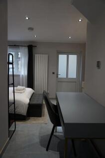 A tidy, modern single bedroom featuring a comfo...