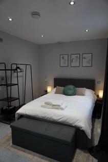 A neatly arranged double bedroom featuring a co...