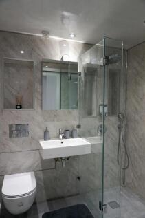 A sleek, modern bathroom suite featuring marble...
