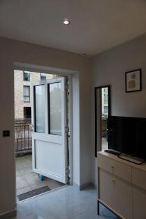 Bright entrance area with a modern white door o...