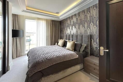 A stylish master bedroom featuring a plush doub...