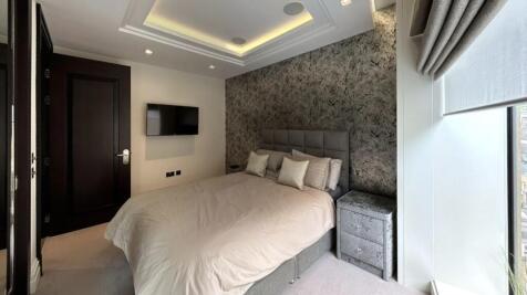 A stylish master bedroom featuring a comfortabl...