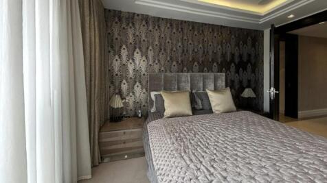 A stylish master bedroom featuring a plush doub...