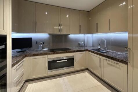 Modern kitchen featuring sleek beige cabinetry,...