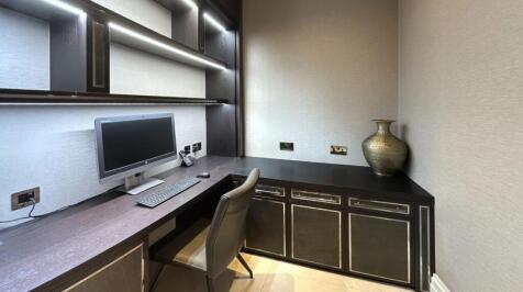 A modern communal workspace featuring a sleek b...