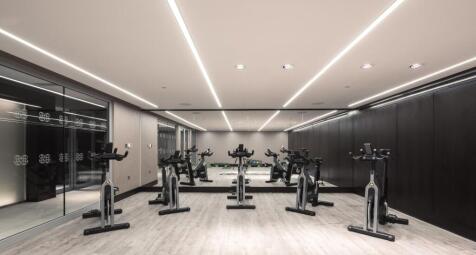 Modern gym space featuring multiple stationary ...