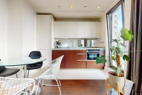 A modern kitchen area featuring sleek white and...