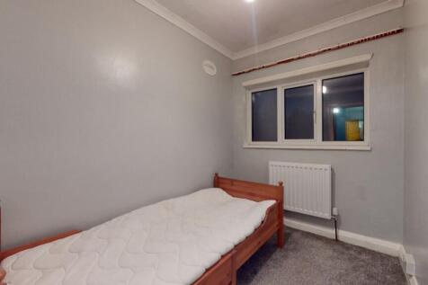 A simple and neat bedroom featuring a single wo...