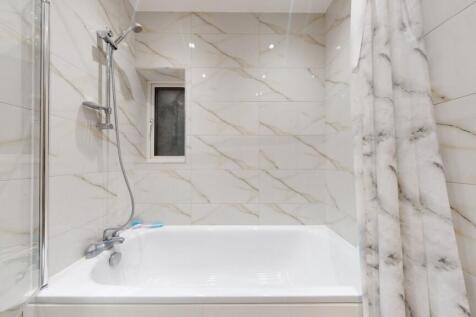 A modern bathroom suite featuring a clean white...