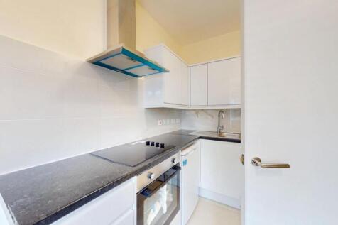 A modern kitchen featuring sleek white cabinets...