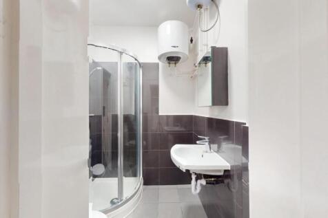 Modern bathroom featuring a curved glass shower...