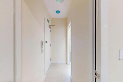 A clean and bright hallway with neutral walls, ...