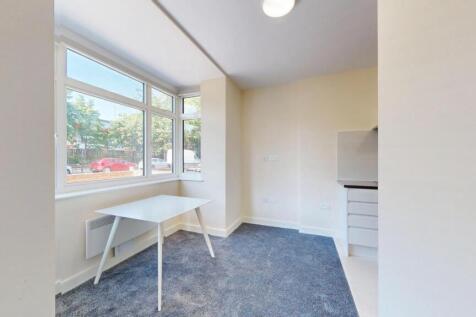 A bright and tidy small room with a large windo...