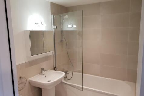 A modern bathroom suite featuring a clean white...