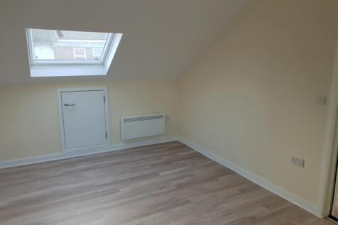 A clean and bright single bedroom featuring lig...