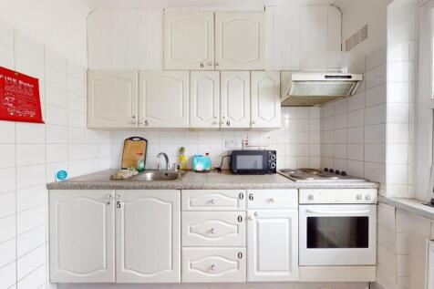 Bright and tidy kitchen with classic white cabi...