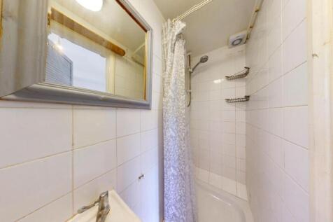 Bright and clean bathroom featuring a shower ar...