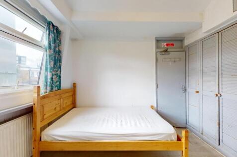 Bright single bedroom featuring a wooden bed fr...