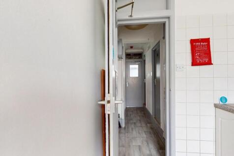 A clean and well-maintained hallway with tiled ...