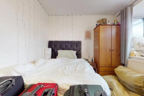 A cozy double bedroom featuring a plush grey he...