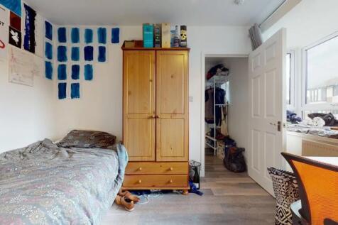 A cozy single bedroom featuring a comfortable b...