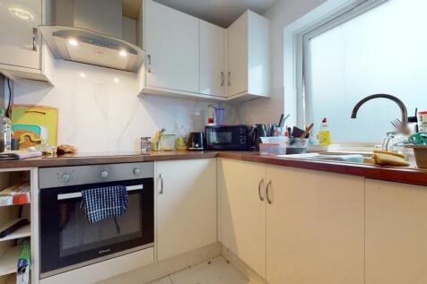 A bright kitchen with modern white cabinetry an...