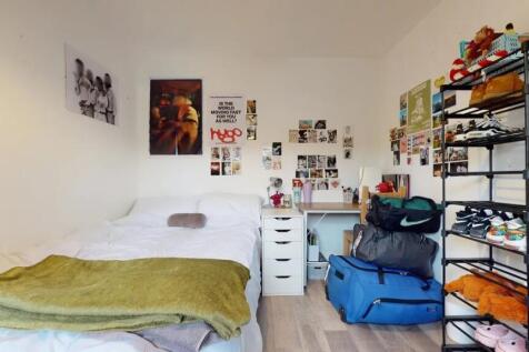 A cozy single bedroom featuring a neatly made b...