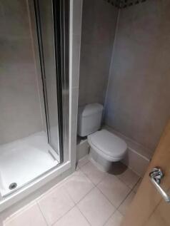 A modern bathroom featuring a clean tiled showe...