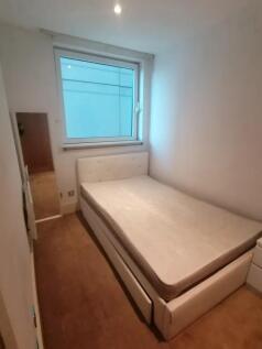 A neat and tidy single bedroom featuring a comf...