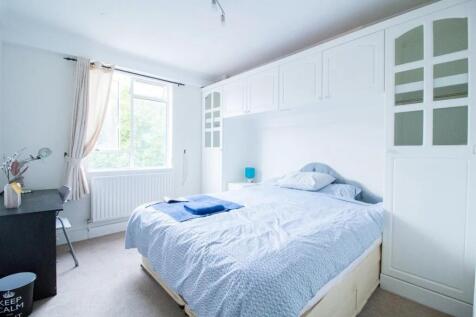 Bright and airy master bedroom featuring a comf...