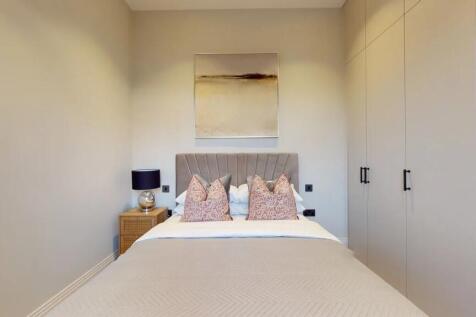 A neatly arranged double bedroom featuring a co...