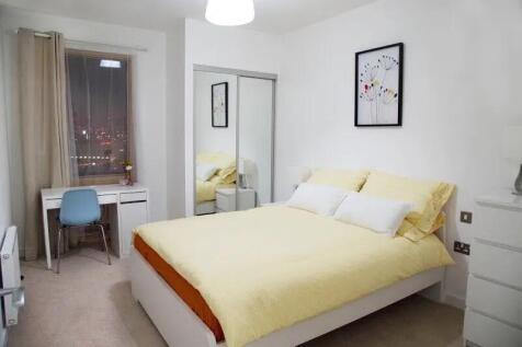 A bright and modern master bedroom featuring a ...