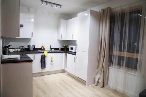 A modern kitchen with clean white cabinets and ...