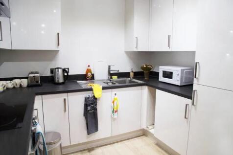 Modern kitchen with sleek white cabinets and bl...
