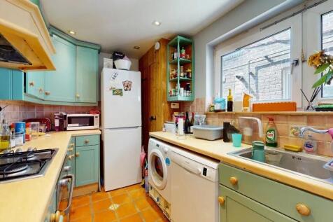 Bright and charming kitchen featuring pastel gr...