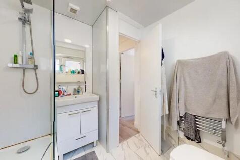 Bright and modern bathroom featuring a walk-in ...