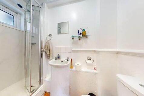 Bright and clean bathroom featuring a glass-enc...