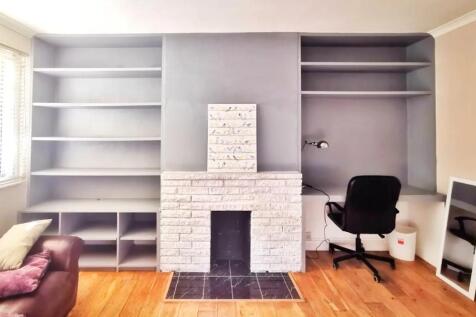 Bright living room with built-in shelving surro...