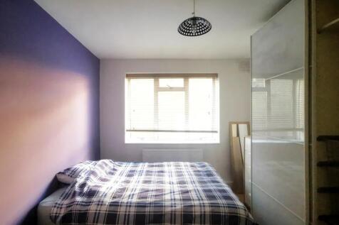 A cozy double bedroom featuring a stylish plaid...