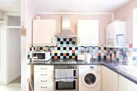 Bright and tidy kitchen featuring colorful tile...