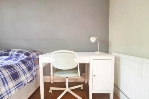 A bright and tidy bedroom featuring a comfortab...