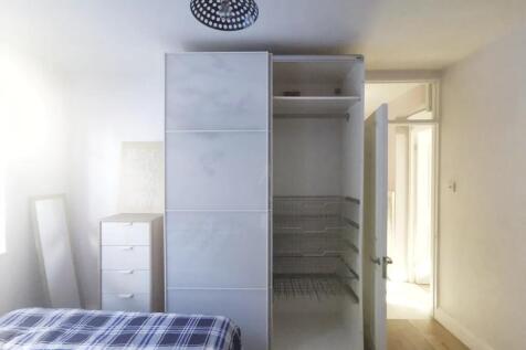 A bright single bedroom featuring a neatly made...