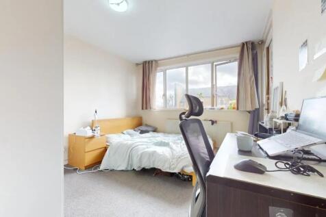 A cozy and well-lit bedroom featuring a large w...