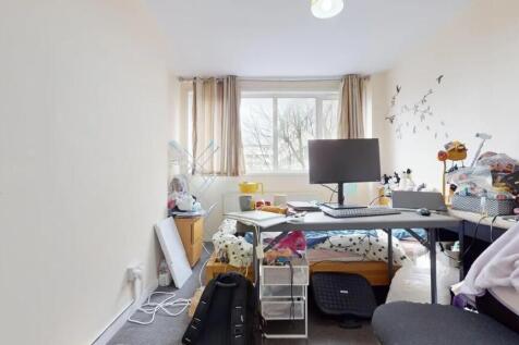 A compact bedroom featuring a large window that...