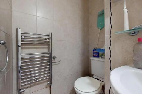 A compact and clean single toilet room featurin...